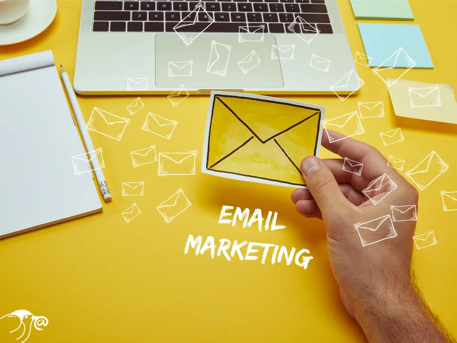 Hand holding an envelope icon with laptop and notepad in background, symbolizing chiropractic email marketing and patient communication strategies.