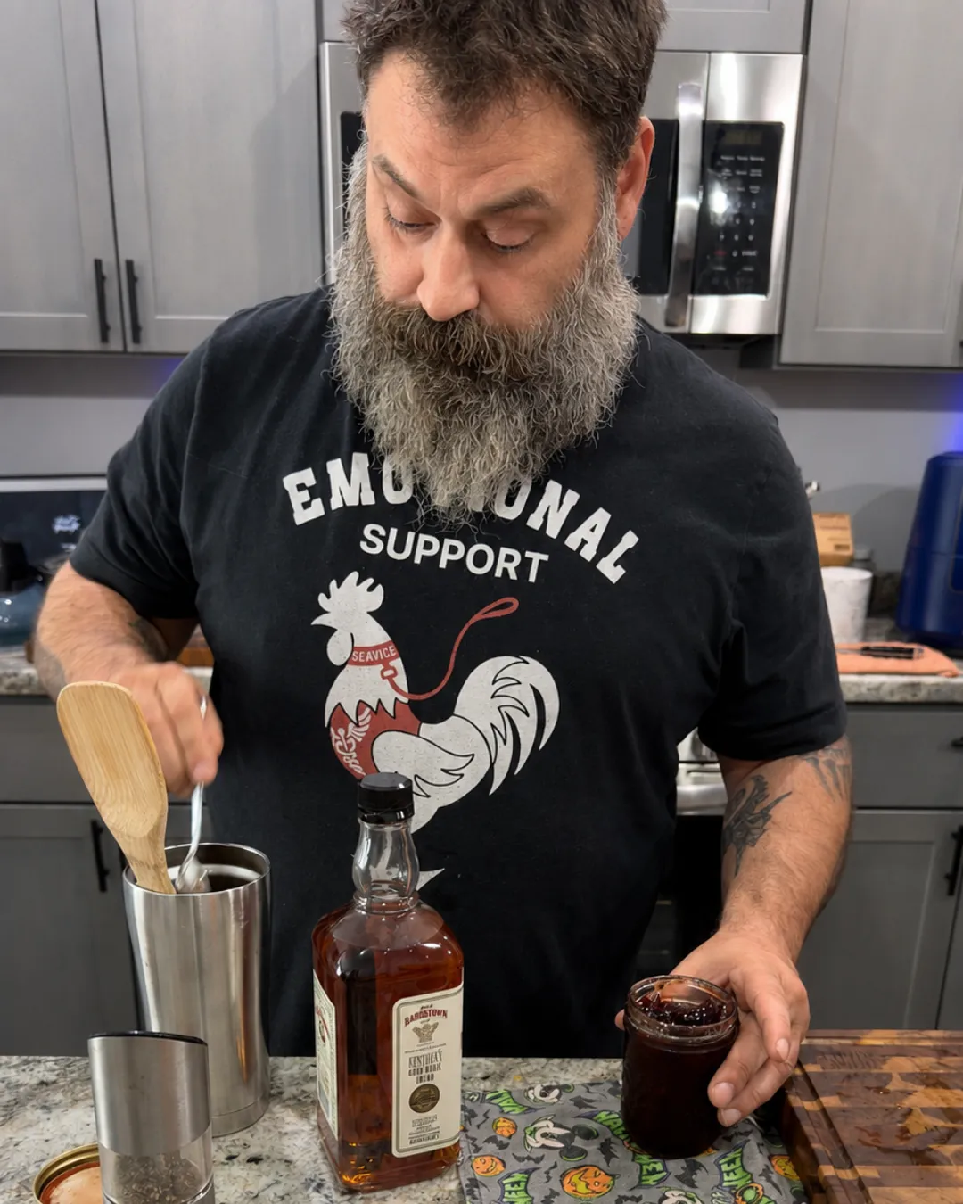 Greg making a smoked old fashioned at the kitchen counter, cocktail smoker and torch in hand.